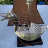 Old vintage lamp representing a duck in silver metal with wooden base