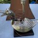 Old vintage lamp representing a duck in silver metal with wooden base