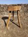 Rustic three-legged stool in minimalist wood in the style of Touret.