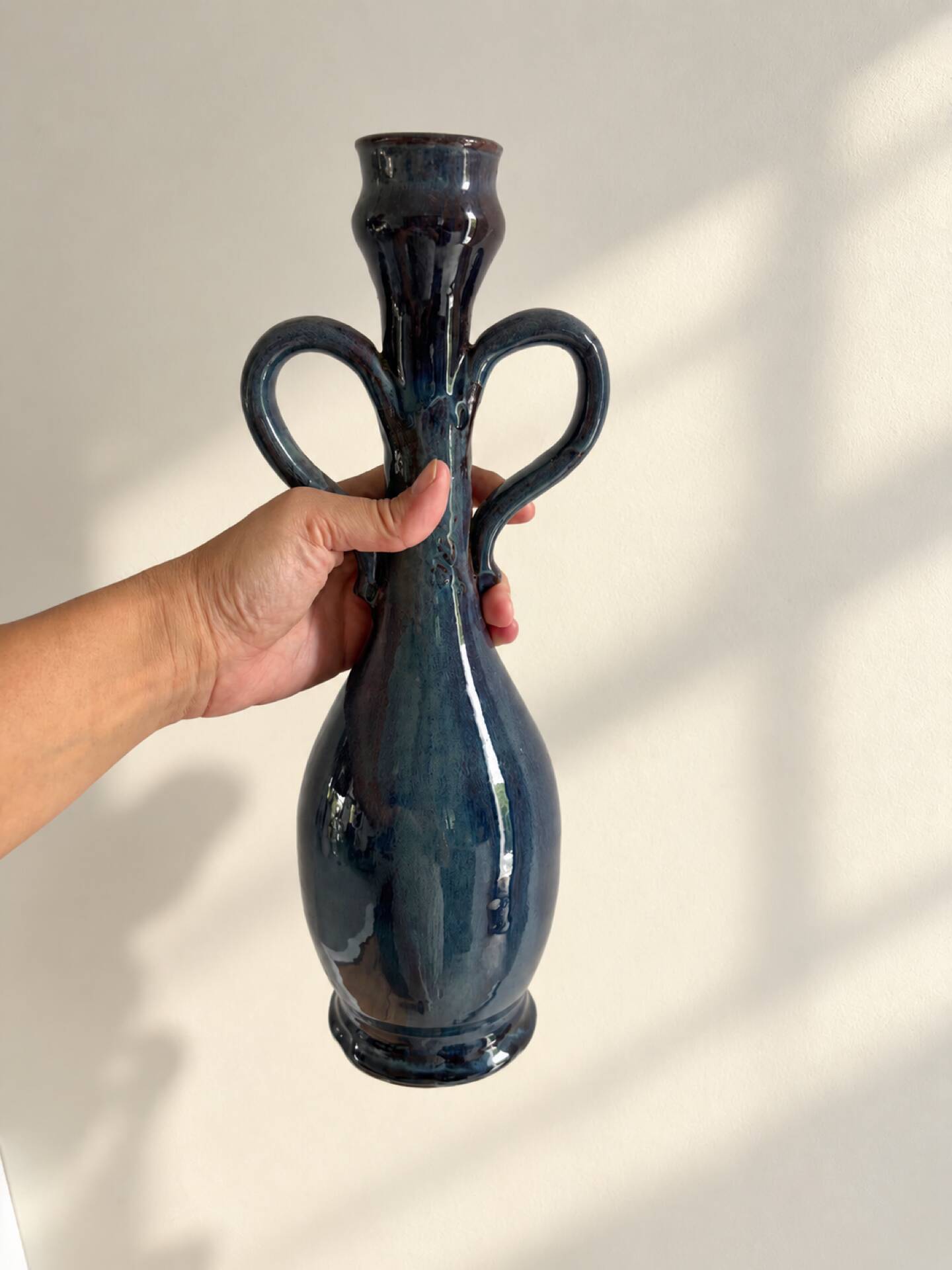 Decorative deep blue glazed ceramic vase with twin handles.