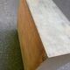 Beige wooden storage cabinet on wheels in industrial style.