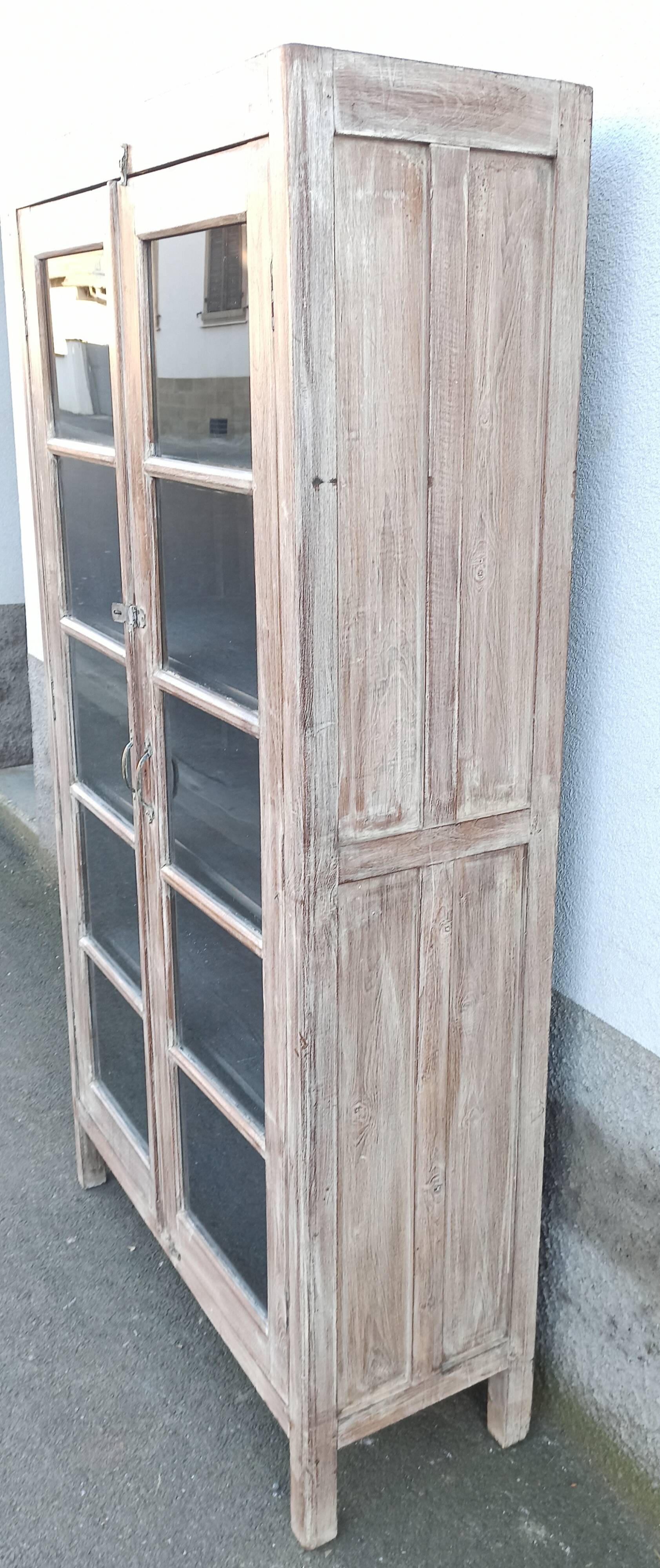 Glass cabinet in old whitewashed wood