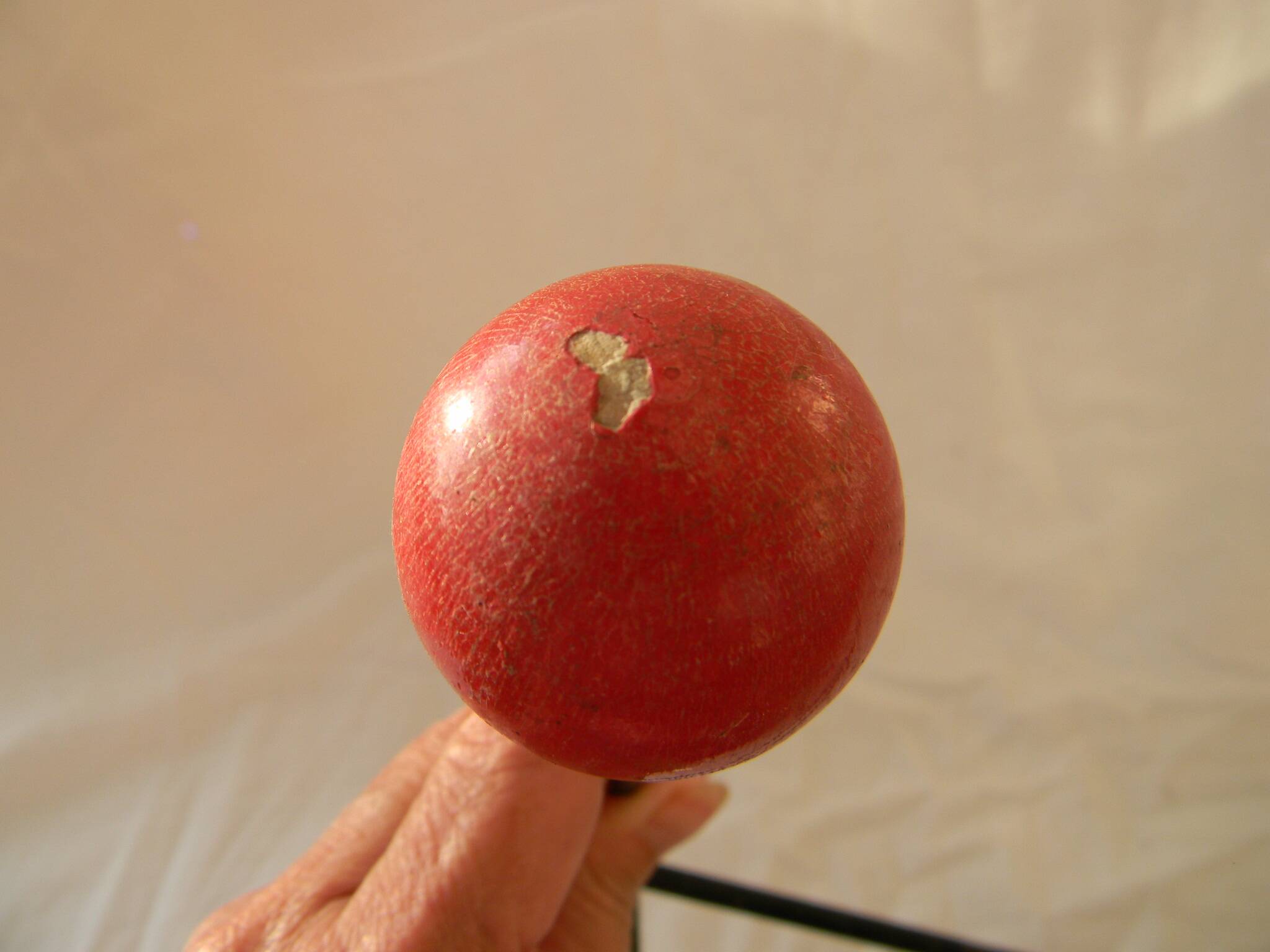 Small wrought iron coat rack with wooden balls.