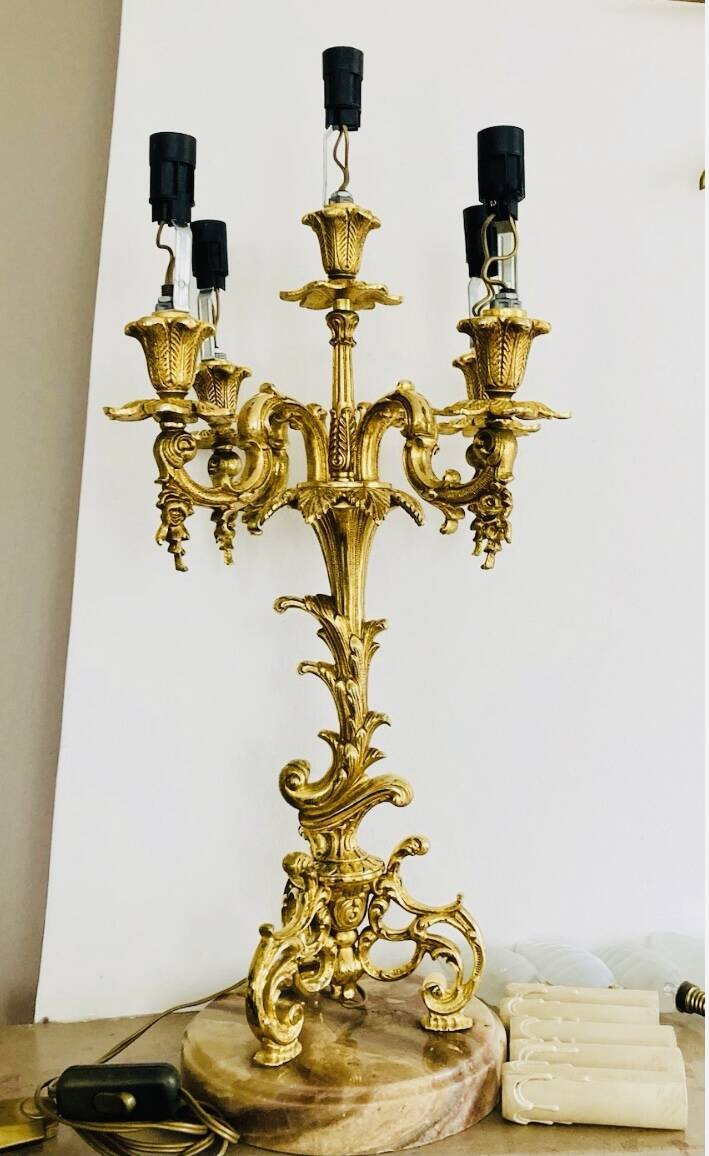 Massive gilded bronze chandeliers from the mid-20th century with marble bases.
