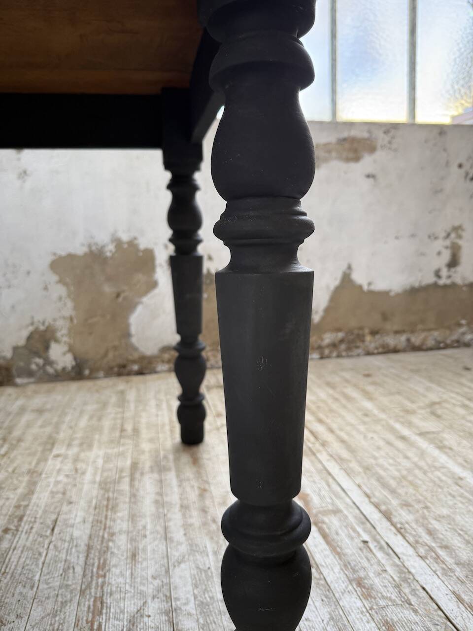 Oak farmhouse table with turned black legs.