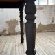 Oak farmhouse table with turned black legs.