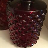 2 red molded glass bottles or jars