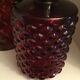 2 red molded glass bottles or jars
