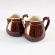 Duo of brown enamel pitchers