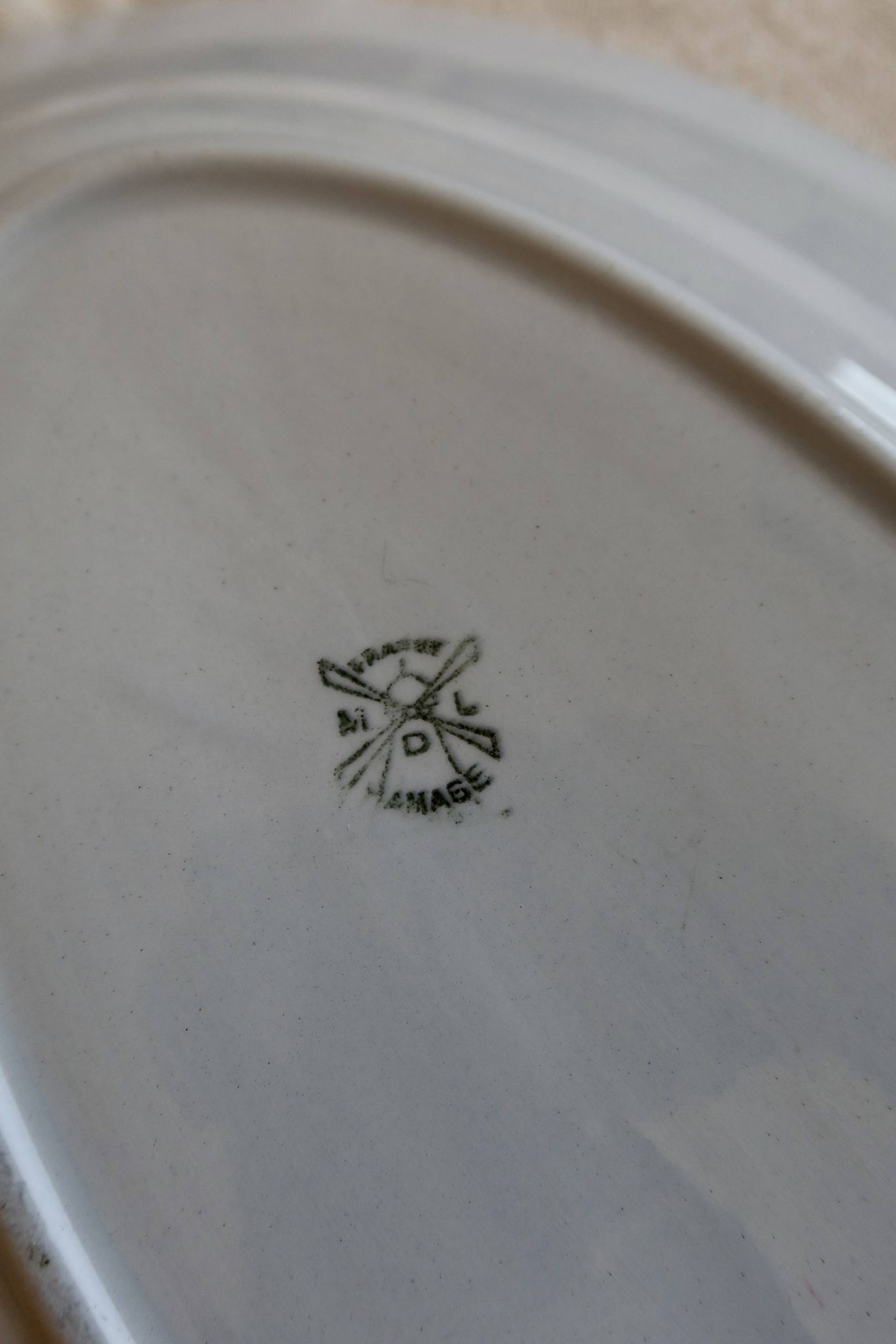 Antique oval serving dish in pale blue earthenware with a small flower design.