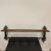 Large antique wall-mounted coat rack in wrought iron.