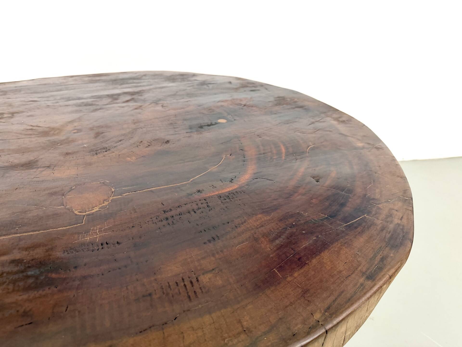 Brutalist coffee table in solid teak, monolithic slab, tripod base.