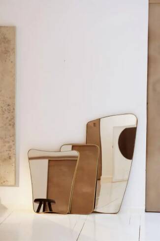 Contemporary rectangular mirror with rounded edges and embossed brass frame.