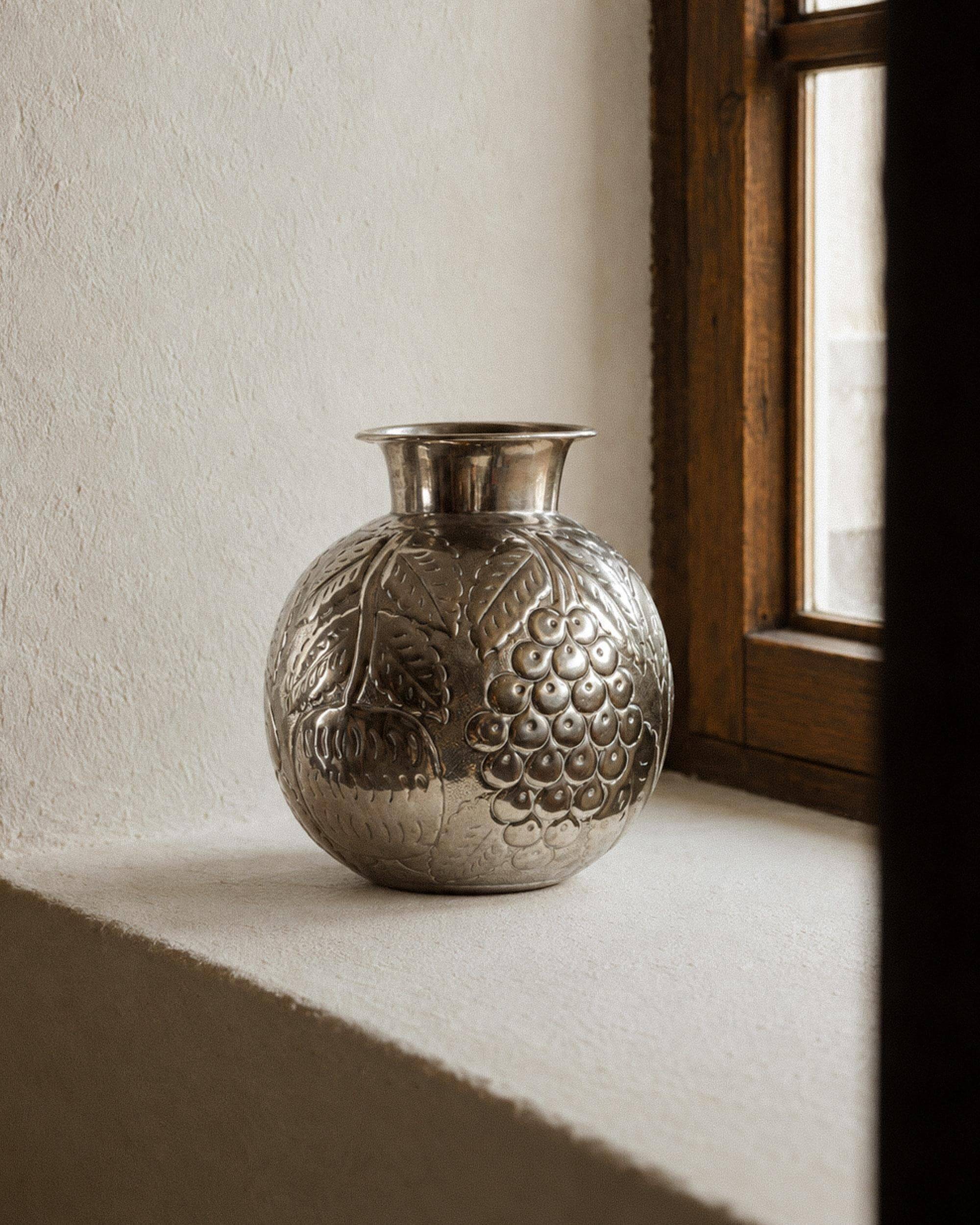 Vintage Italian vase in nickel-plated brass from the 1960s, hand-hammered relief of fruits and leaves.
