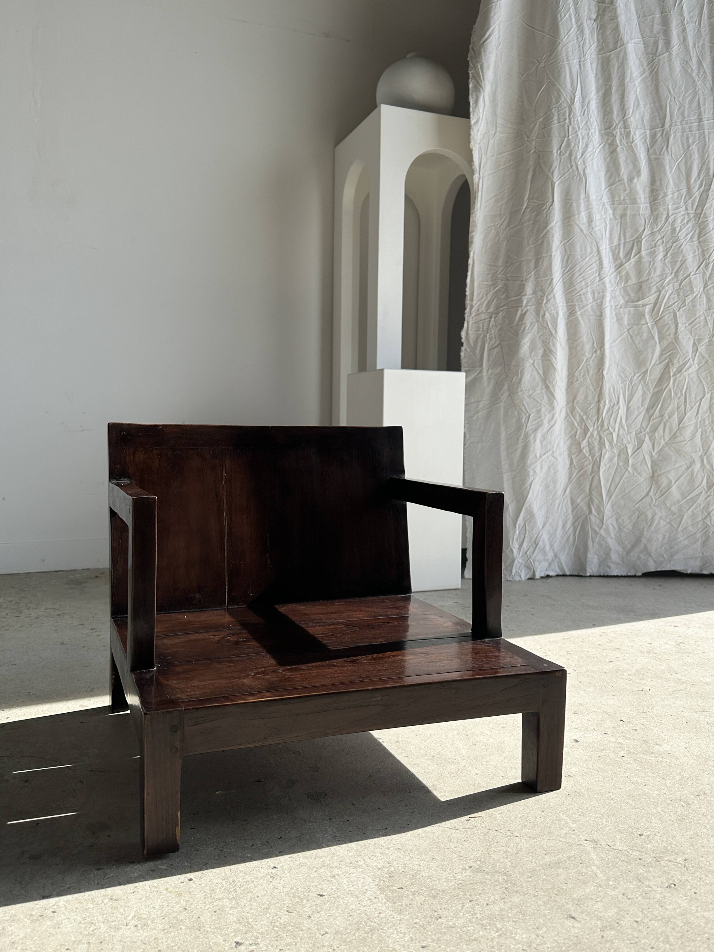 Small low armchair in varnished brown wood