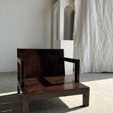Small low armchair in varnished brown wood