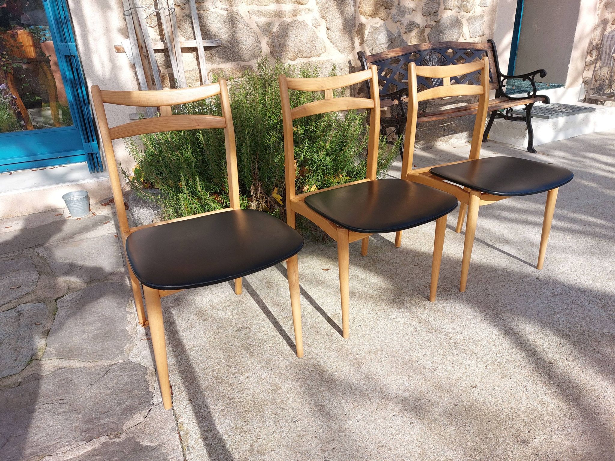 3 Scandinavian style chairs, light wood and black faux leather.