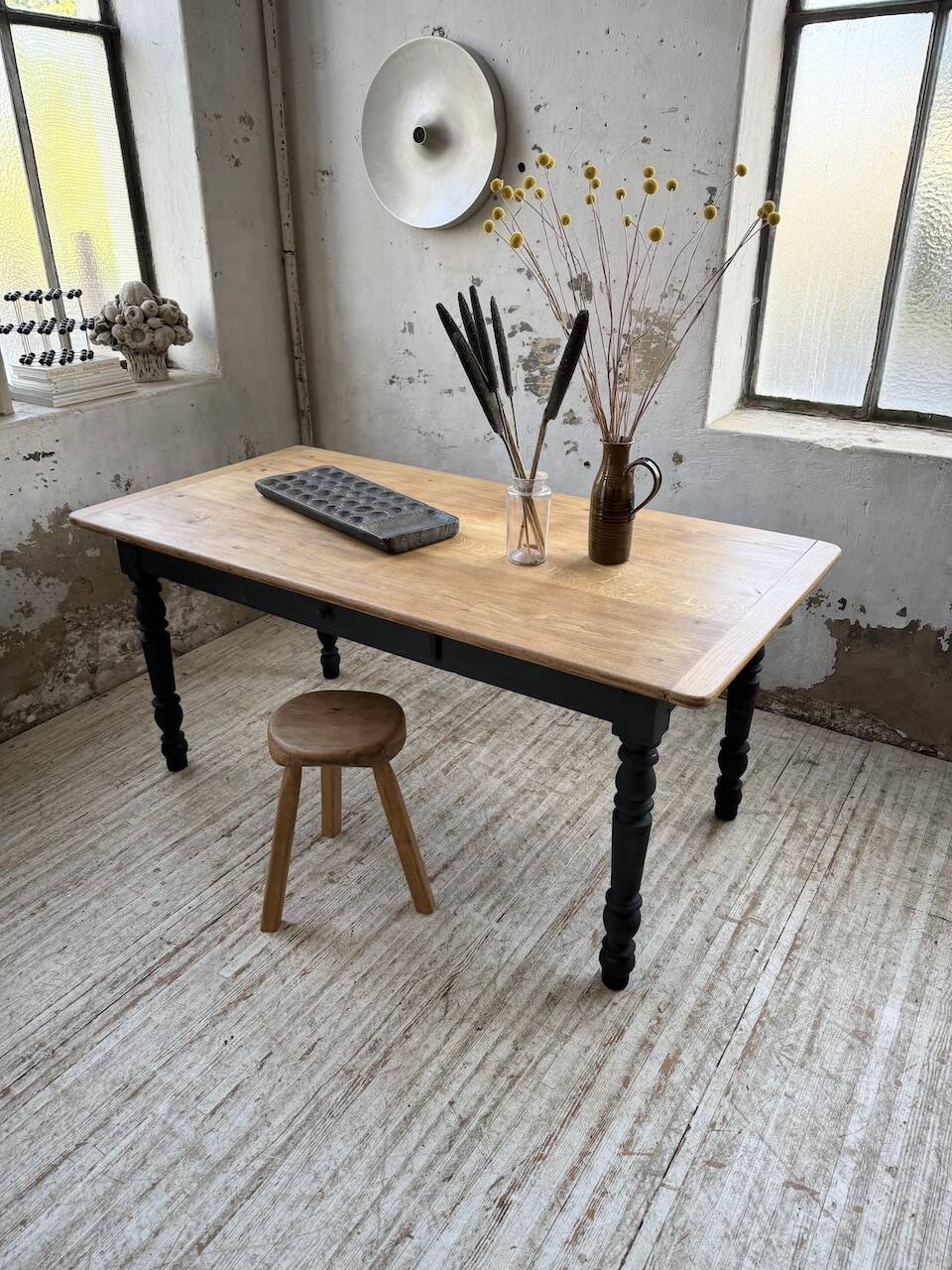 Oak farmhouse table with turned black legs.