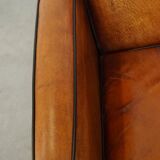Sheepskin Art Deco design armchair with beautiful wooden details and black piping