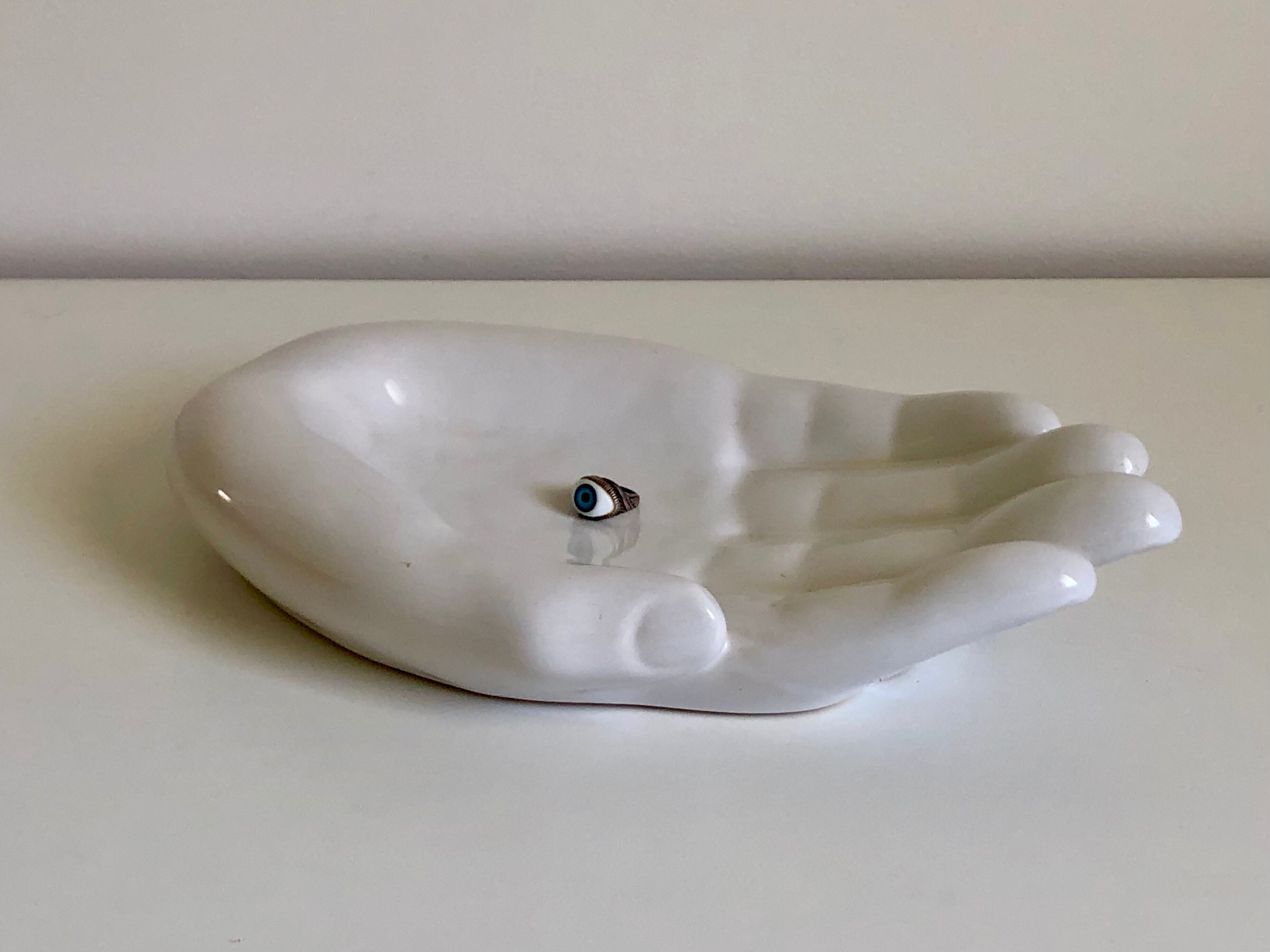 Empty white enamelled ceramic pocket in the shape of a large hand, 1990