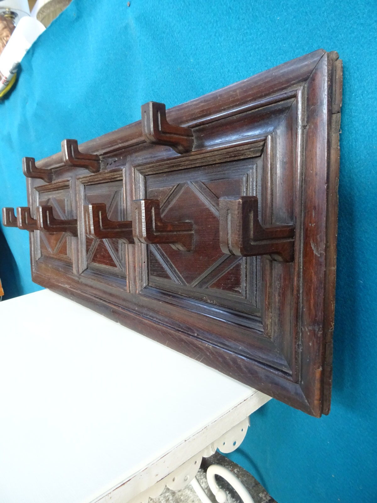 Wall-mounted coat rack in solid oak with 9 hooks.