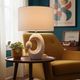 Cream ceramic table lamp with a mid-century design, featuring a lampshade.