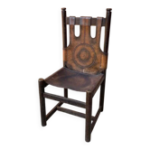 Fauteuil artisanal en cuir marron, structure bois foncé, motif circulaire - années 70