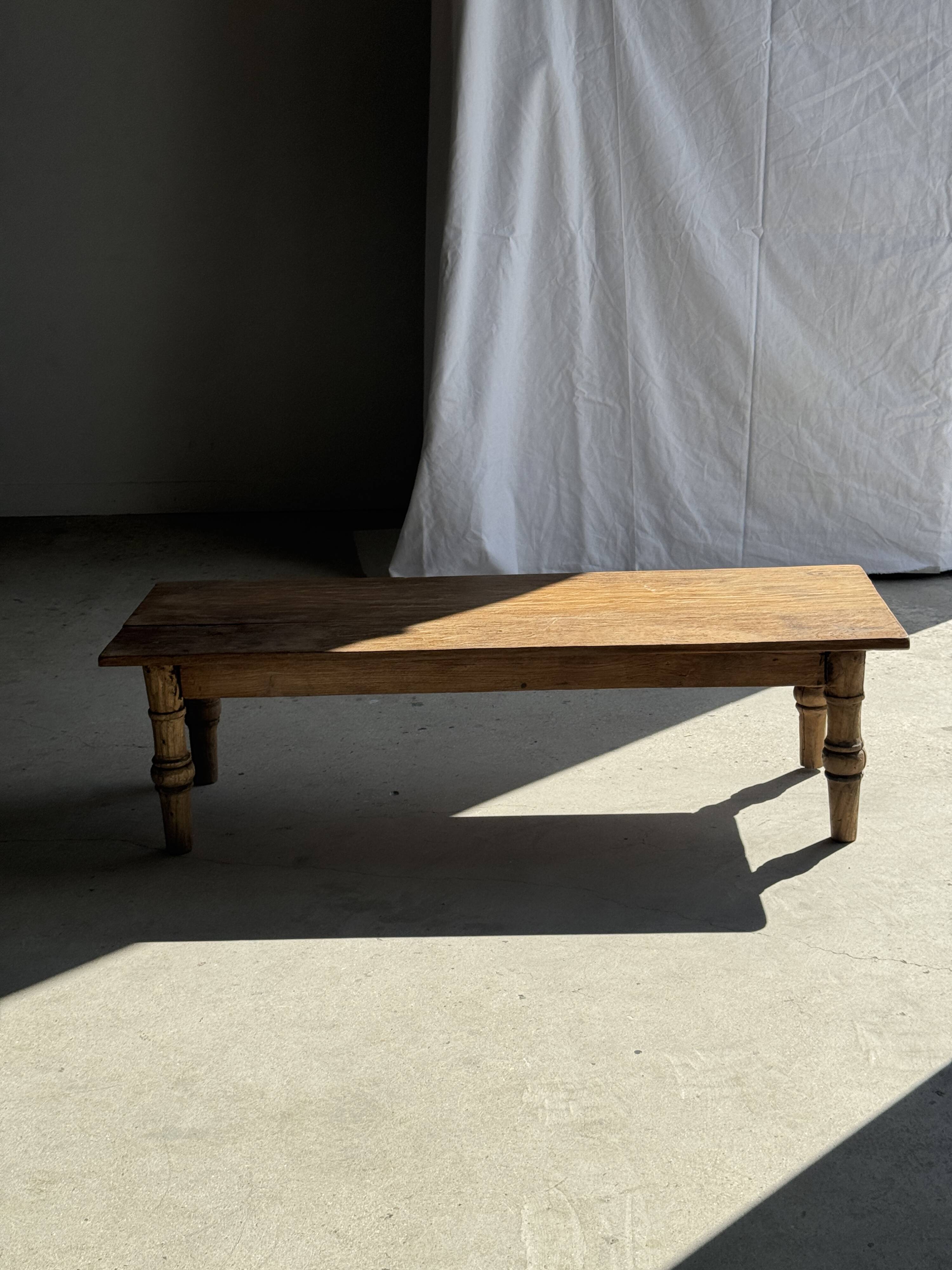 Brown Indonesian teak coffee table, with a border and cylindrical legs H40 L103.
