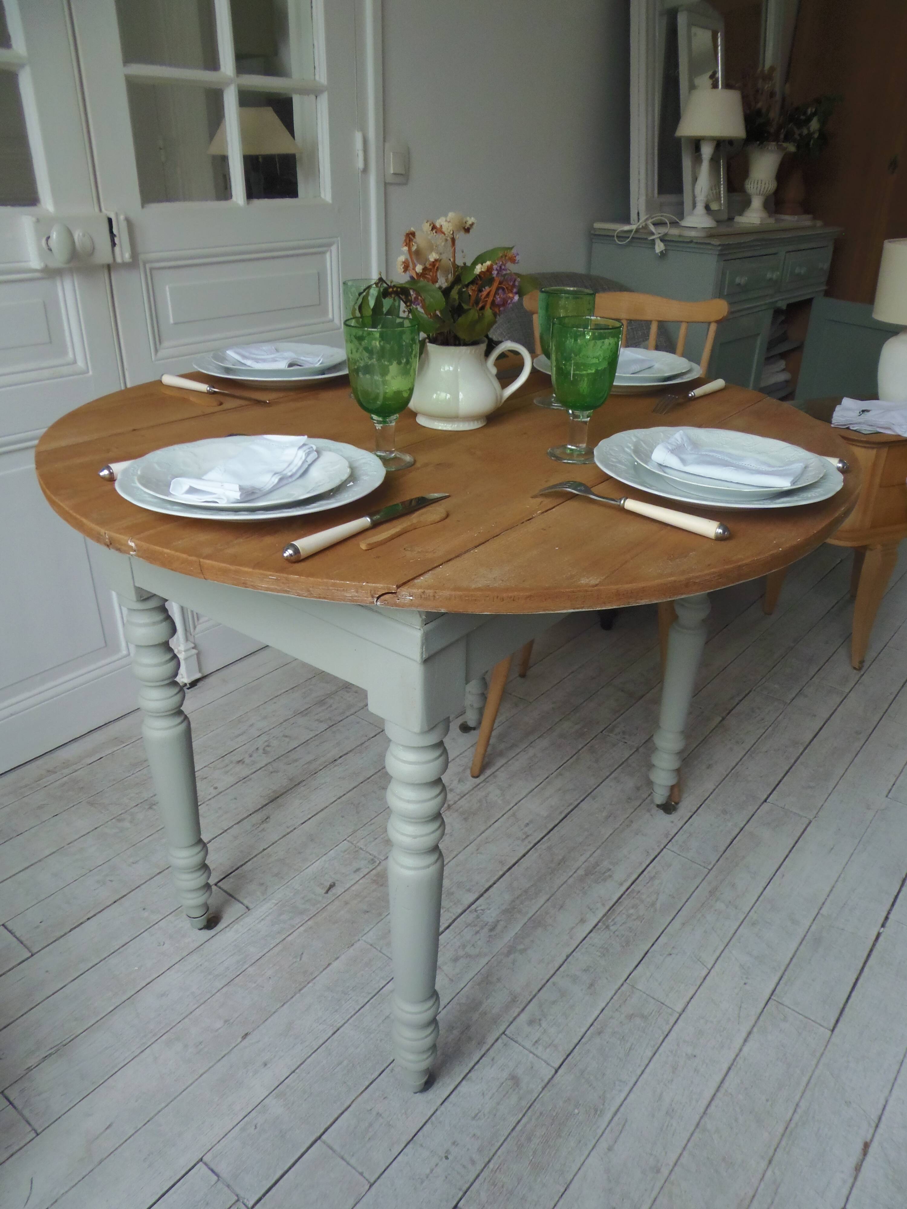 Walnut table with raised flaps, base on verdigris casters.