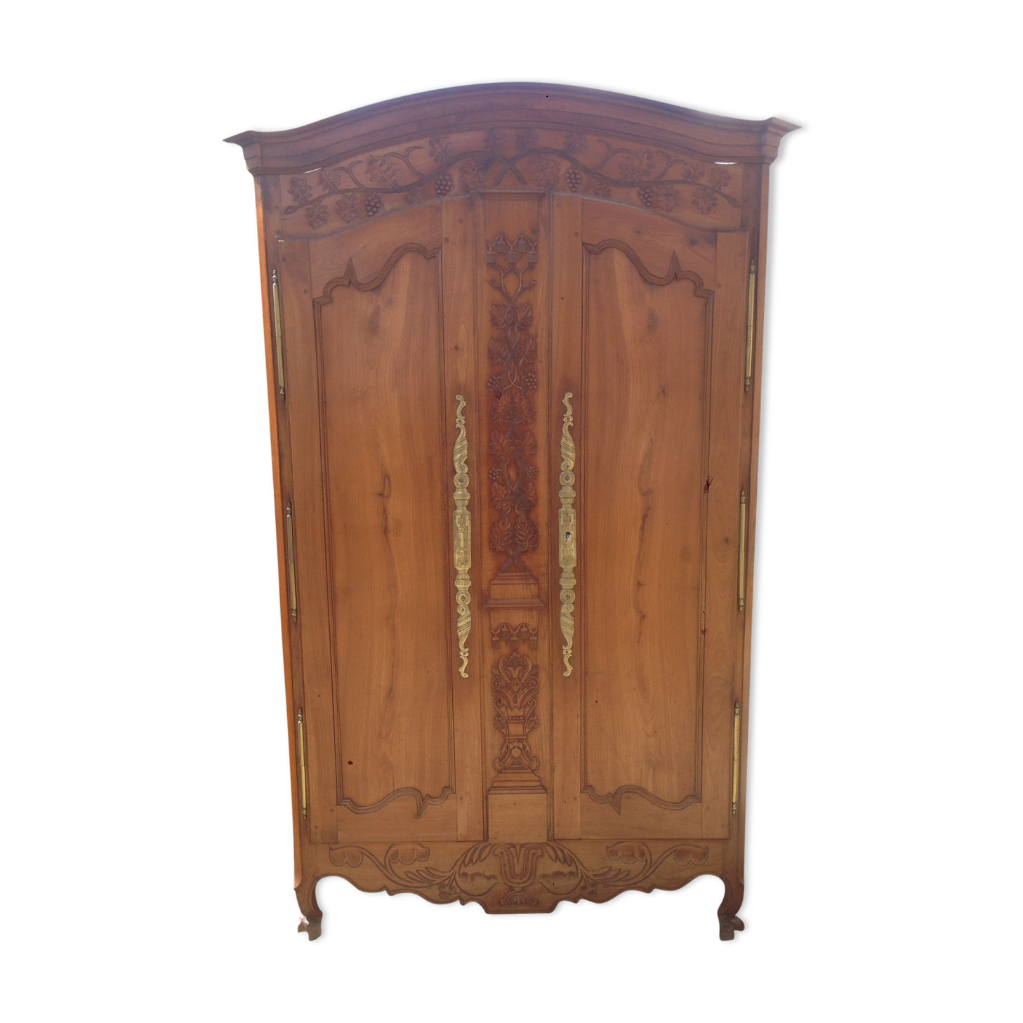 Armoire Louis XV Nantaise sculptée à grappes de raisin, chapeau de gendarme en cerisier fin 19eme.