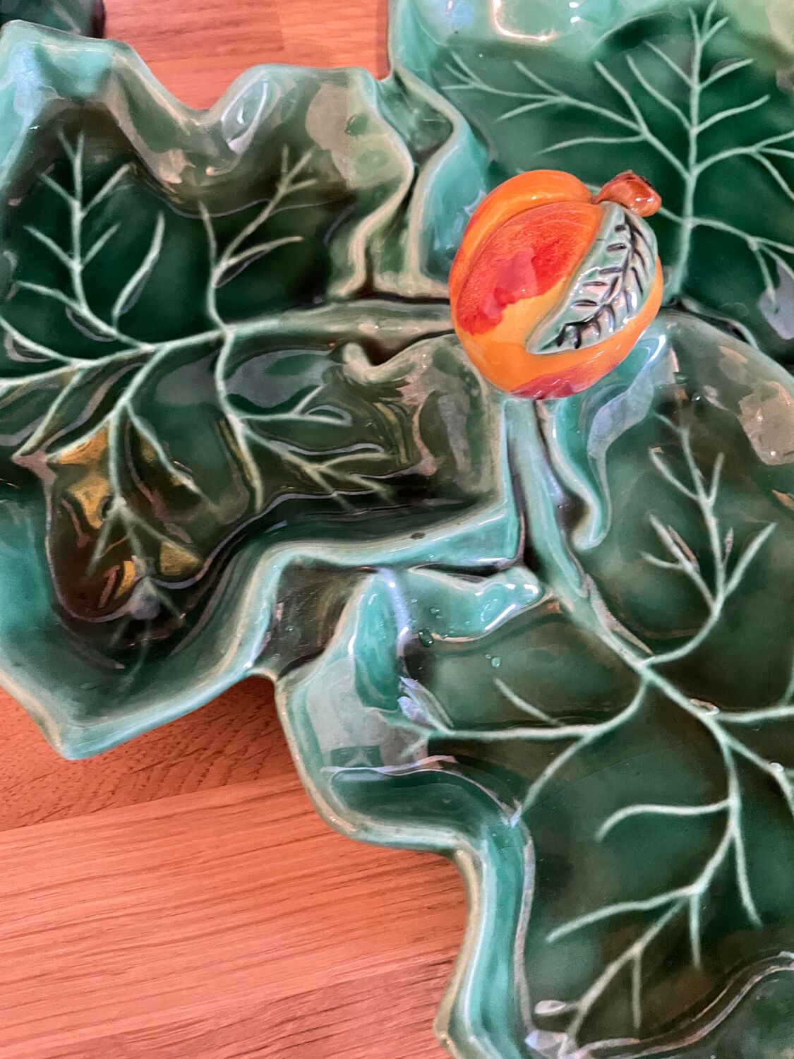 Old dish in green slip decor 3 vine leaves and an apple