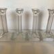 Four old square glass moulded candlesticks.