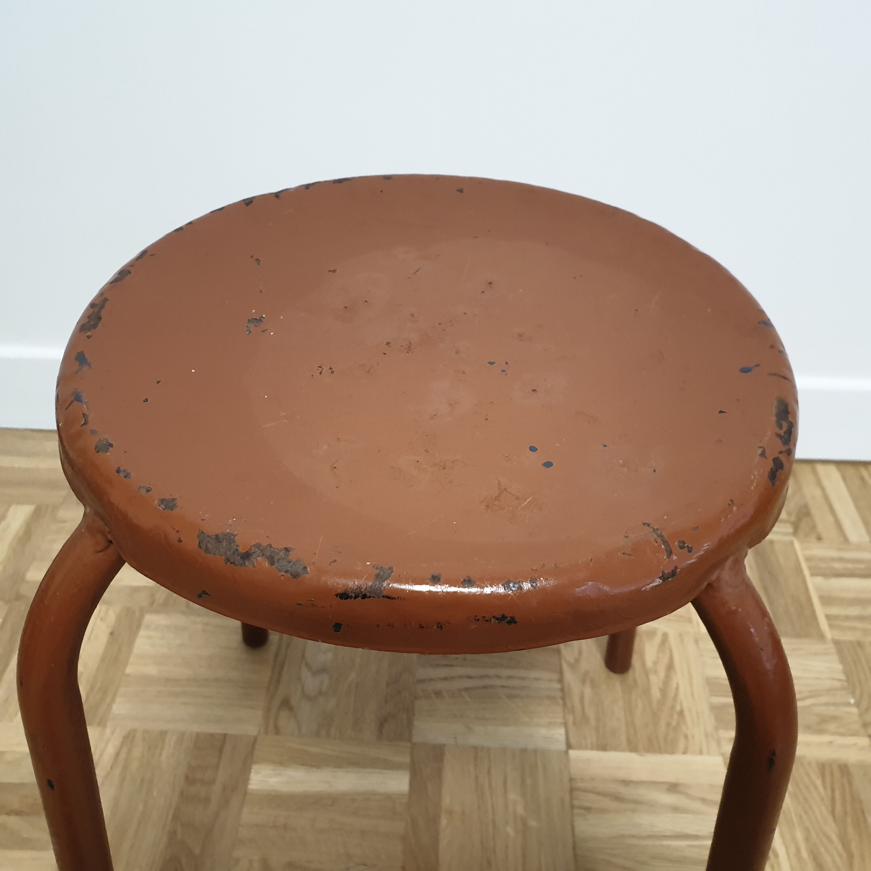 Rust-colored painted metal stool