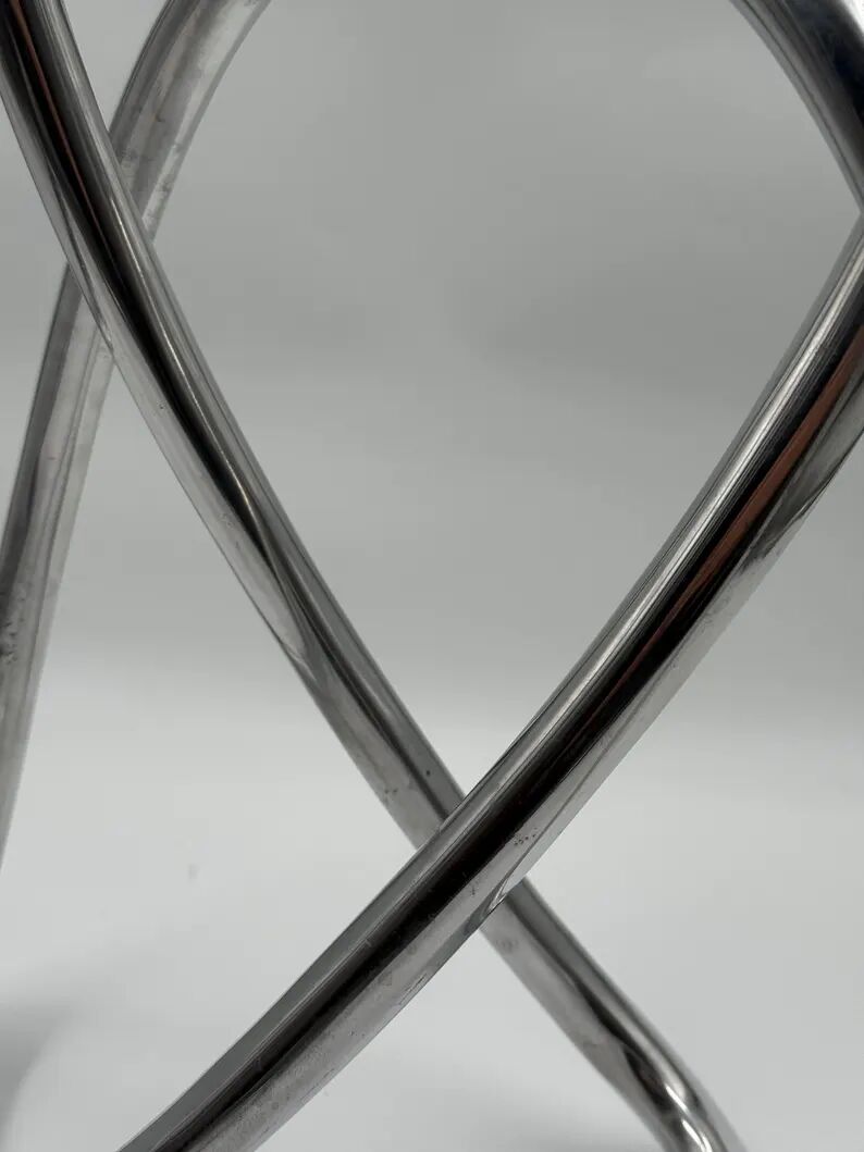 Chromed sculptural art object, abstract modernist shape in metal, contemporary design accent, brutalist interior decoration.