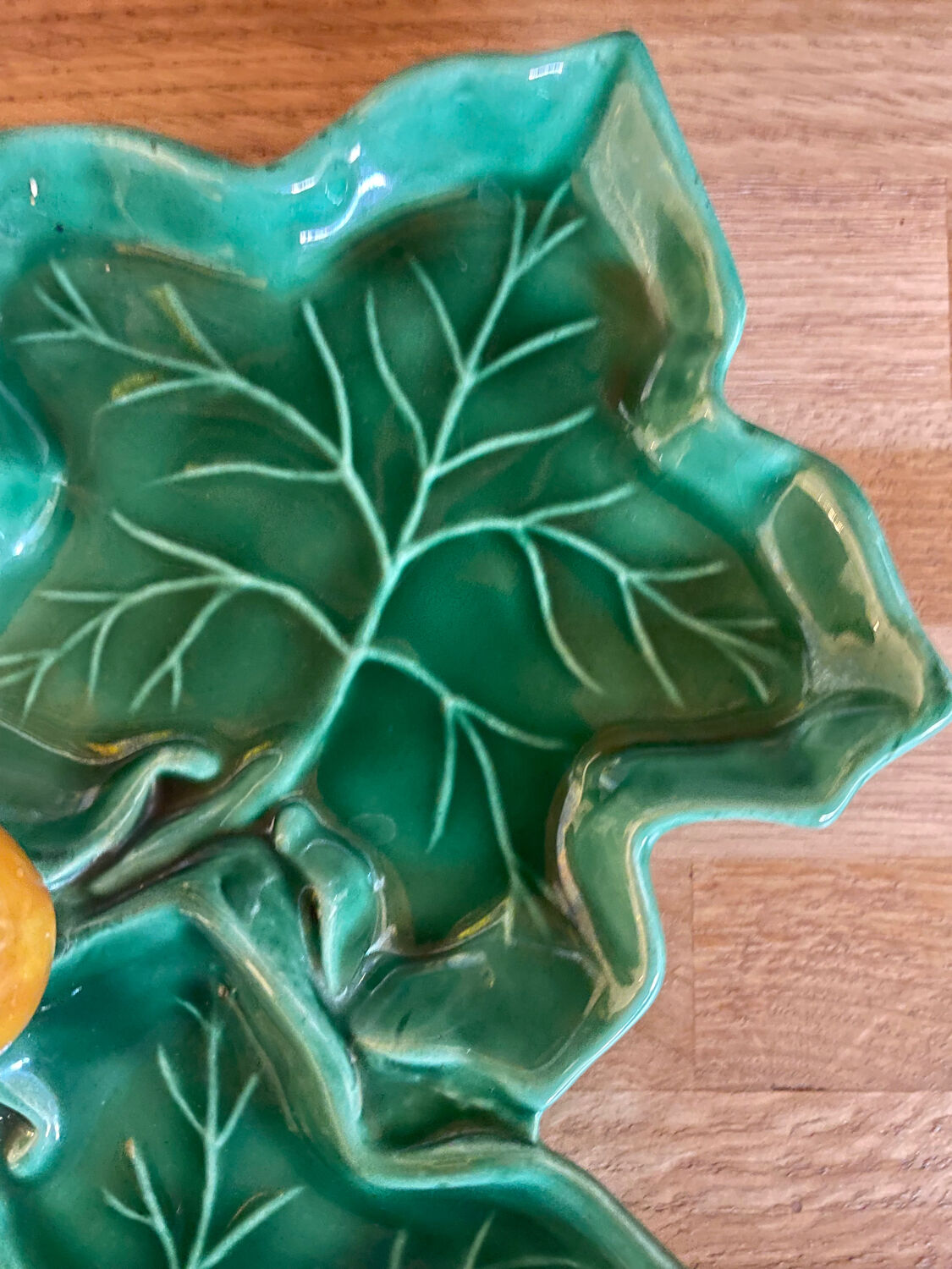 Old dish in green slip decor 3 vine leaves and an apple