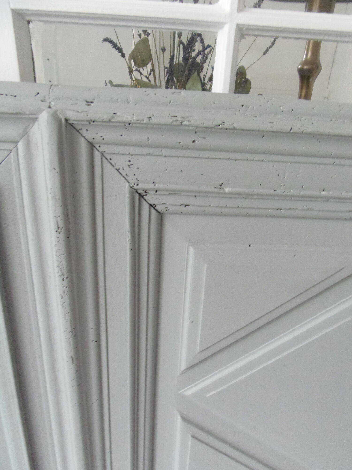 Headboard made with an old walnut door, re-enchanted in gray green waxed finish,
