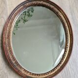 Old oval mirror in gilded wood