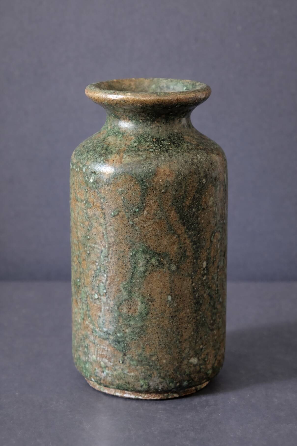 Wabi-sabi artisanal stoneware vase in green and earth tones.