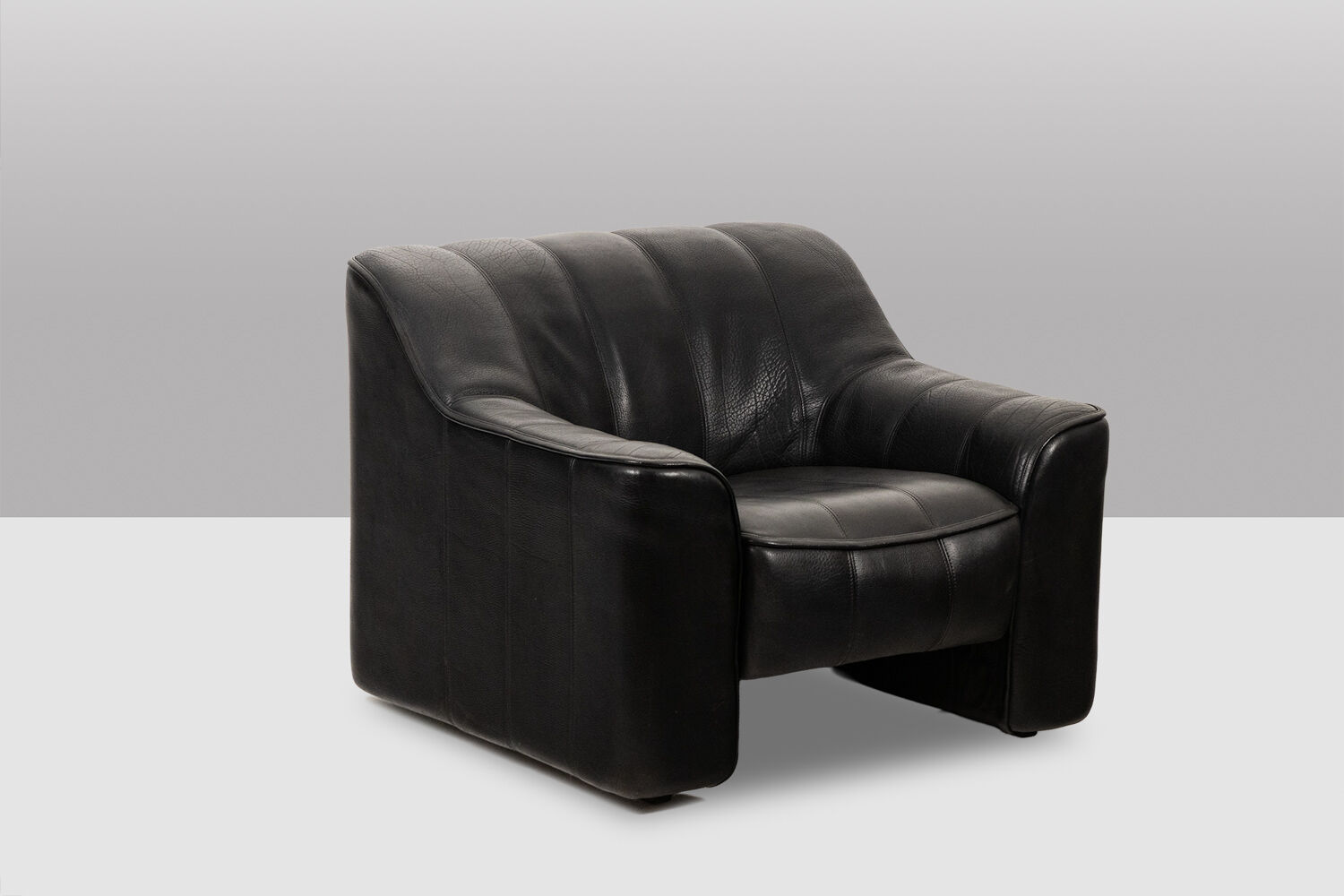 Maison De Sede. Armchair and its ottoman in black leather. 1970s.