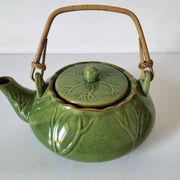 Vintage green teapot with lotus decoration and bamboo handle.