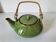 Vintage green teapot with lotus decoration and bamboo handle.