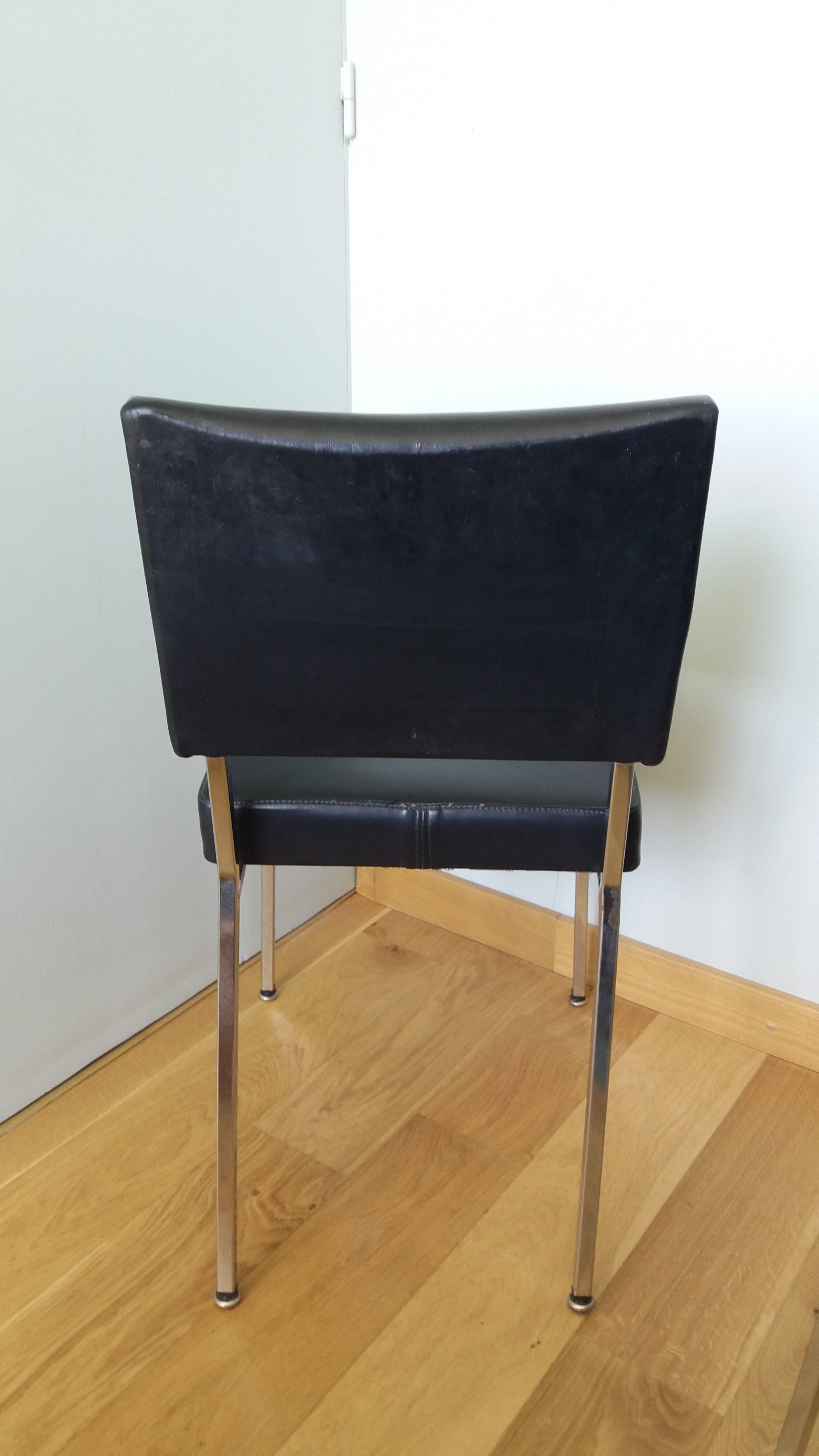 Chrome metal chairs and black faux leather upholstery in retro modernist style.