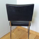 Chrome metal chairs and black faux leather upholstery in retro modernist style.