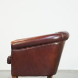 Comfortable, rugged cognac-colored sheepskin club armchair with a characteristic seat cushion