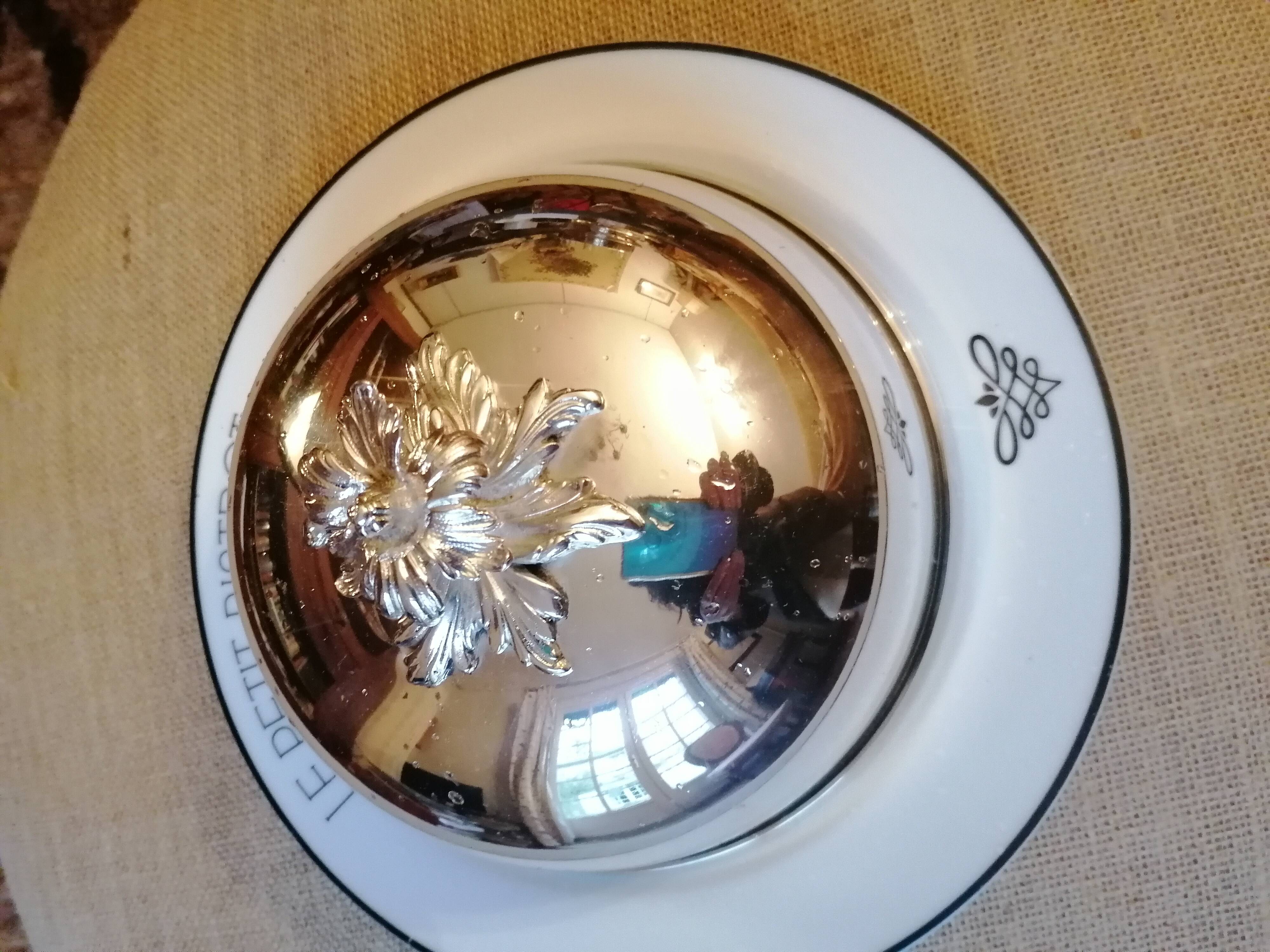 Silver metal bell on its porcelain dish