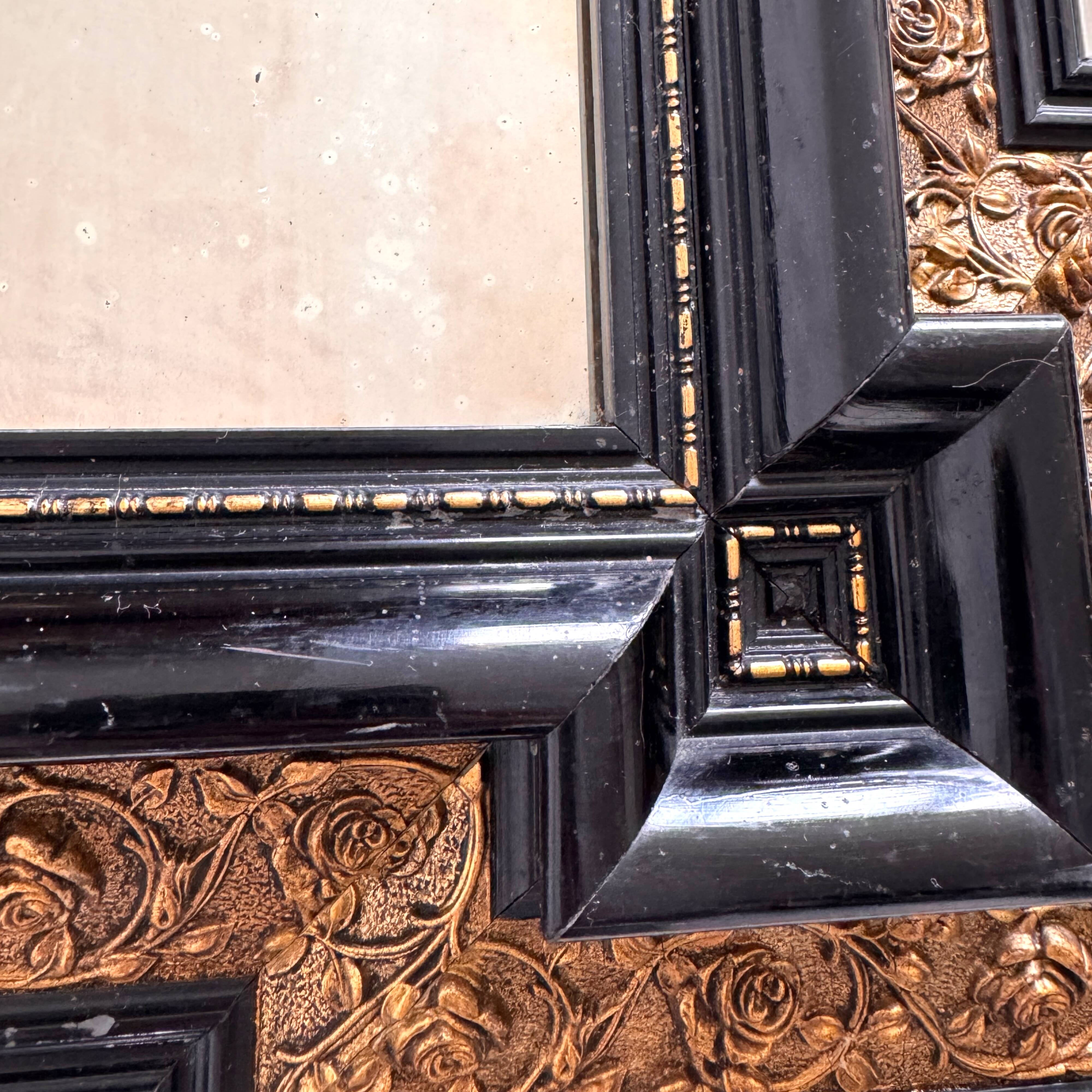 Antique wall mirror in blackened wood and gilded stucco, 19th-century Dutch style.