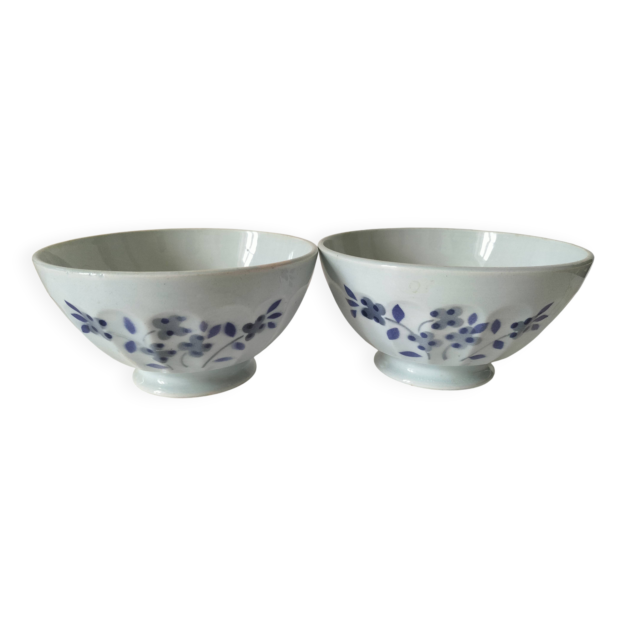 Two vintage farm bowls on a pale blue pedestal with floral decoration.