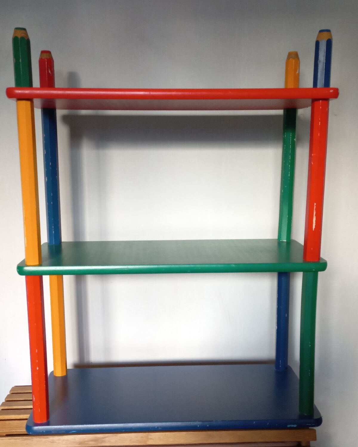 Shelf on legs, library, crayons in 4 colours.