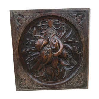 Old carved oak door panel decorated with fish