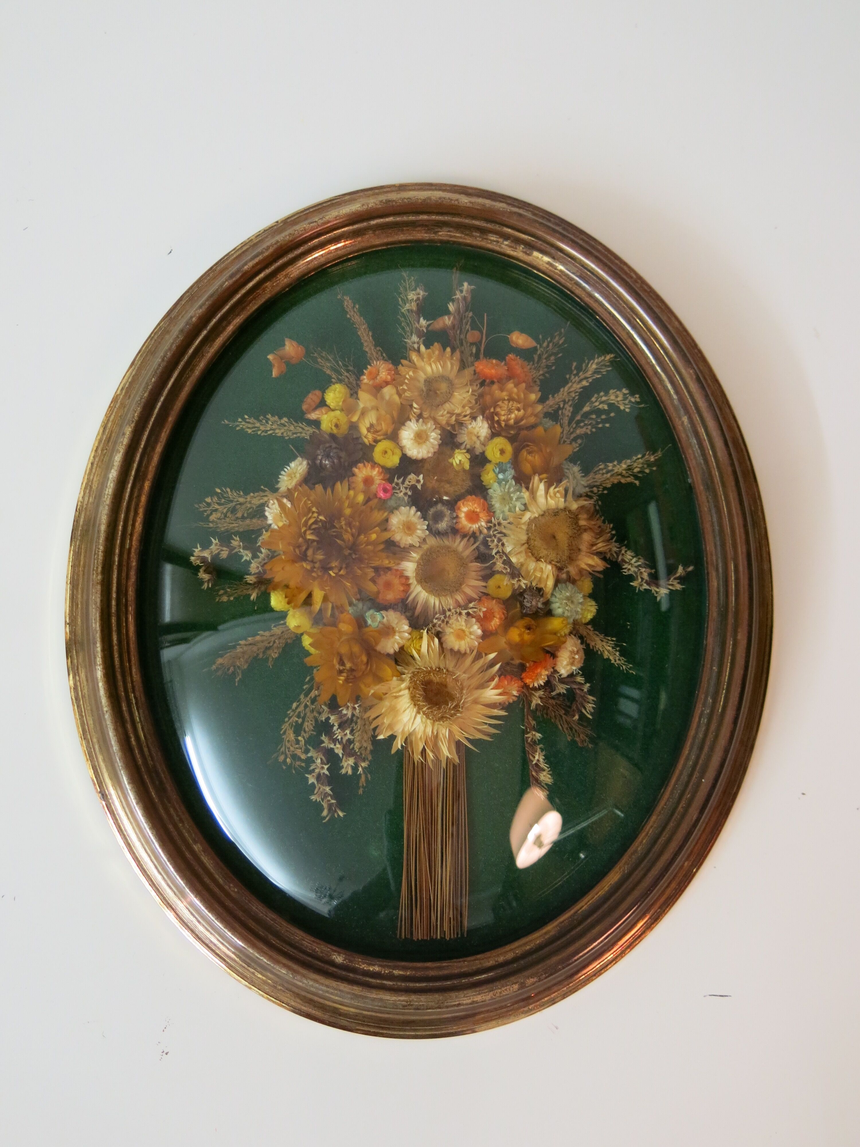 Domed glass frame with its bouquet of dried flowers
